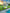 Robotic lawn mower on grass next to a pool with a house in the background