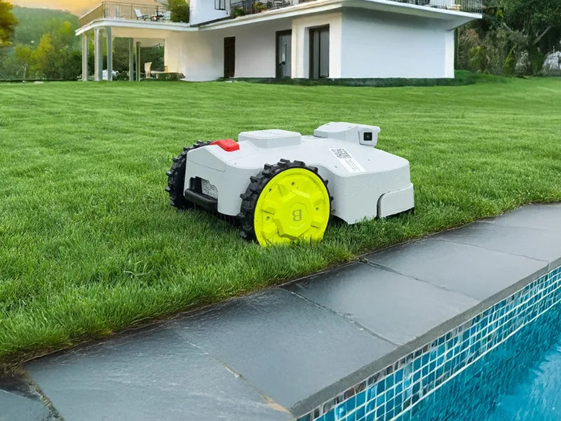 Robotic lawn mower on grass next to a pool with a house in the background