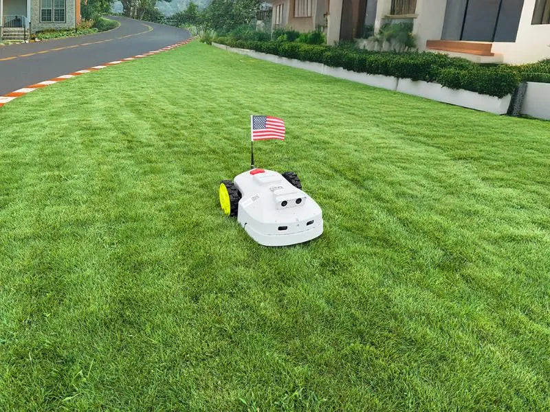 a robot mower with US flag works in front of the house lawn
